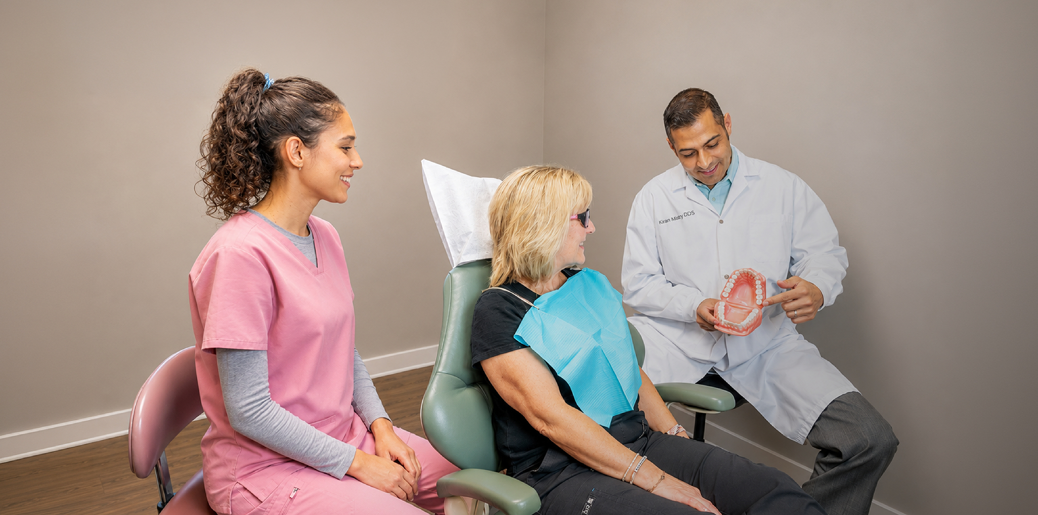 Doctor Mistry showing a dental patient a model of the teeth